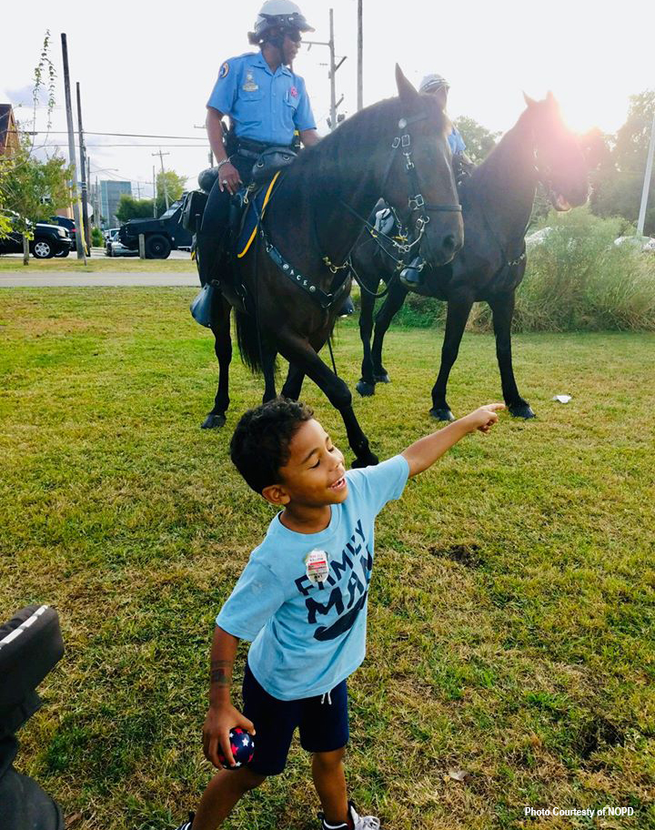 NOPD Mounted Unit dancing with child at Night Out Against Crime